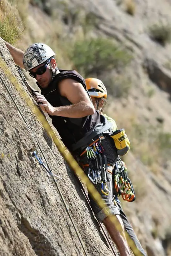 Simon escalando, asegurado por una compañera