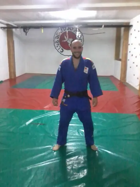 Simon con judogi azul sobre un tatami