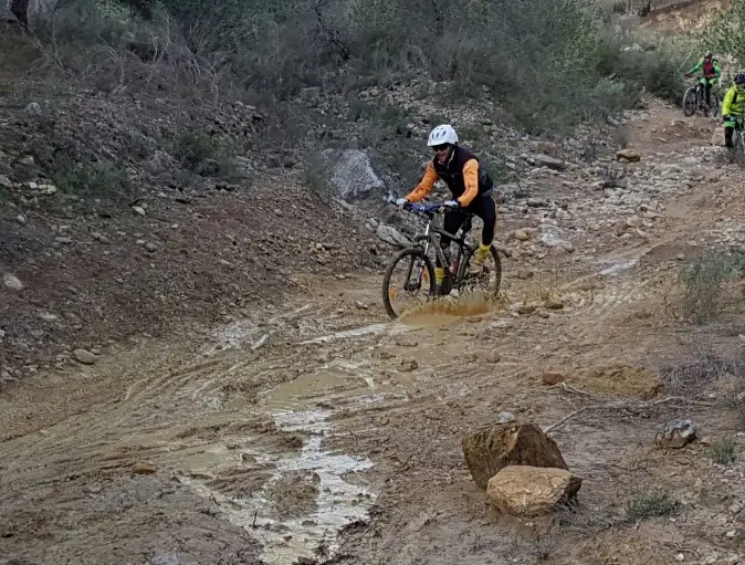 Simon en bicicleta de montaña por un camino embarrado